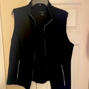 Quilted black vest with silver zippers.